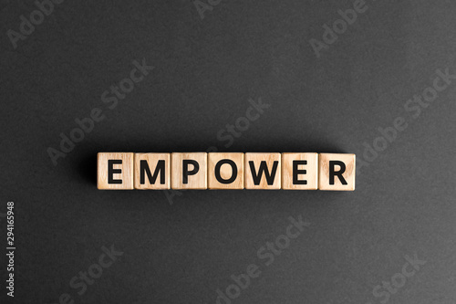 empower - word from wooden blocks with letters, empower concept, gray background