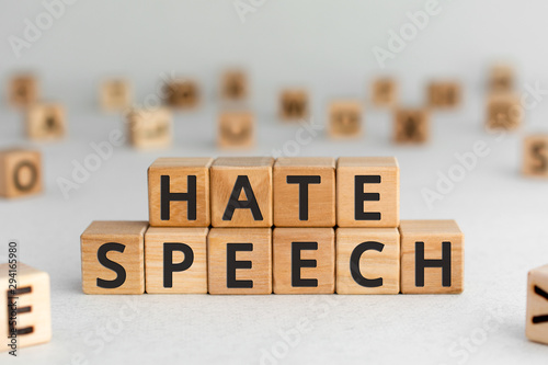 Slika na platnu Hate speech - words from wooden blocks with letters, speech that attacks a basis