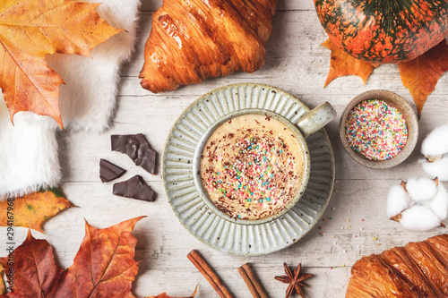 Coffee, croissant, pumpkin, white fluffy sweater on a white background and maple autumn leaves. Autumn concept.