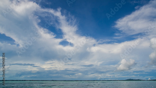 Blue sky with white cloud and sea below.