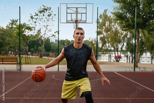 Basketball player in motion on outdoor court © Nomad_Soul