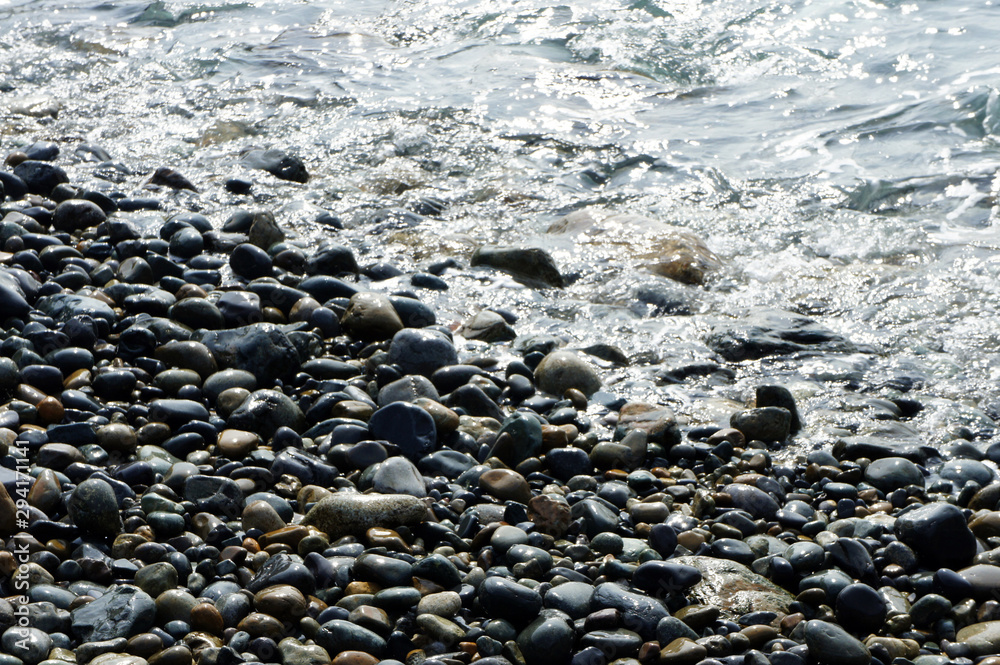 Pebbles being washed in the sea water coming to the beach Pebbles being washed in the sea water coming to the beach