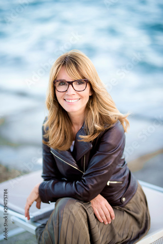Portrait of beautiful woman sitting at the ocean and relaxing