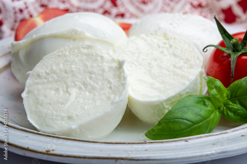 Italian soft cheese mozzarella, white cheese made from cow or buffalo milk with fresh green basil herb and red tomato