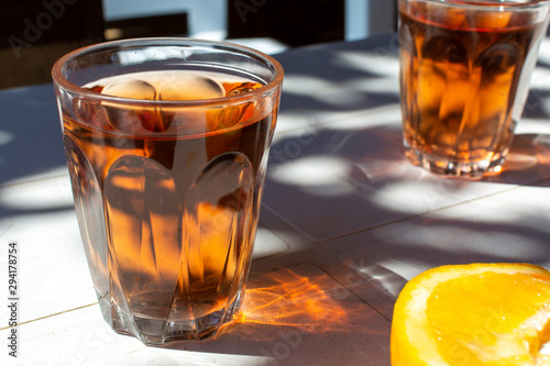 Young rose wine served outside in garden on white table with fresh orange in sun lights