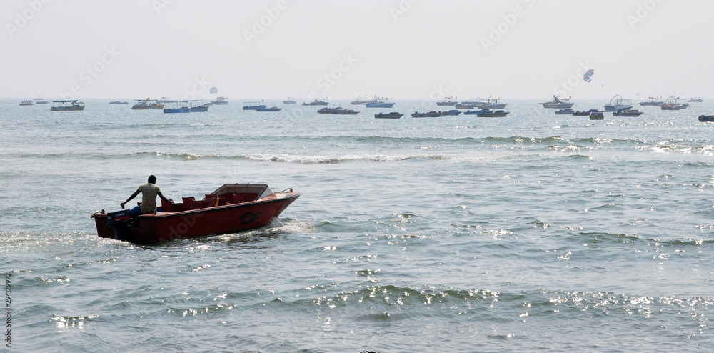 Red motor boat in the sea ocean. On the back a lot of boats. Fisher. Tourist. With man 