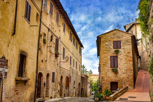 Old cozy street in in old town of San Gimignano, Tuscany, Italy. San Gimignano is typical Tuscan medieval town in Italy