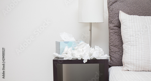 A pile of dirty kleenex on nightstand photo