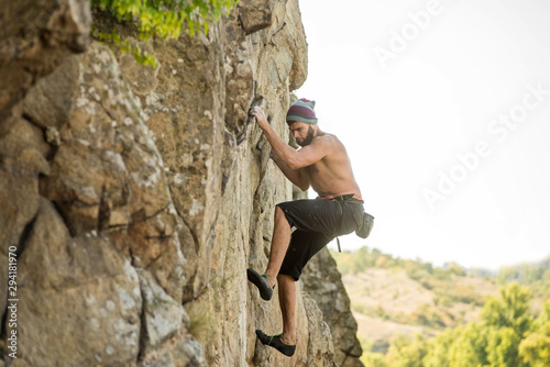 Man climber climbing to the top of the rock.