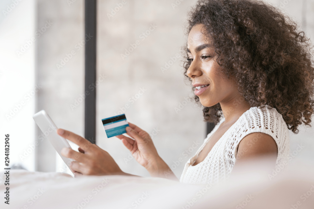 Pleased curly haired girl looking at her tablet Pleased curly haired girl looking at her tablet