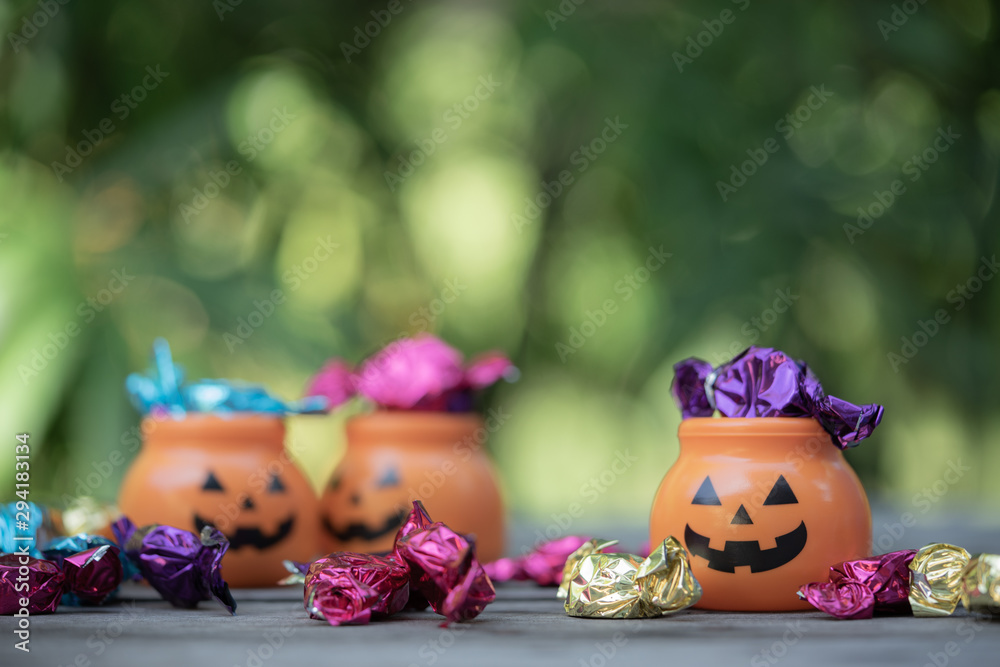Fototapeta premium Halloween jack-o-lantern pail with spilling candy