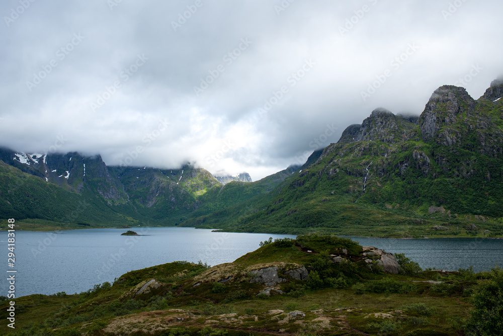 Beautiful nature landscape in North. Scenic outdoors view. Ocean with waves and mountains. Big dark stones. Dramatic storm clouds. Extreme weather, rain and wind. Explore Norway, summer adventure Beautiful nature landscape in North. Scenic outdoors view. Ocean with waves and mountains. Big dark stones. Dramatic storm clouds. Extreme weather, rain and wind. Explore Norway, summer adventure