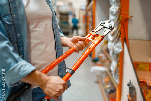 Male customer choosing cutters in hardware store