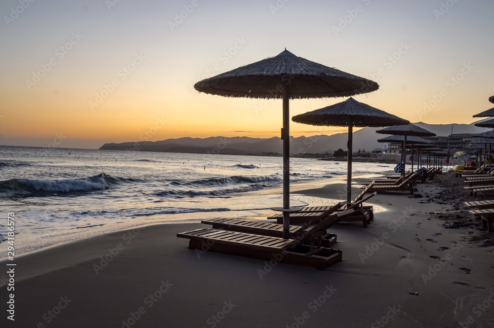 Sunbeds and umbrellas at sunrise Sunbeds and umbrellas at sunrise