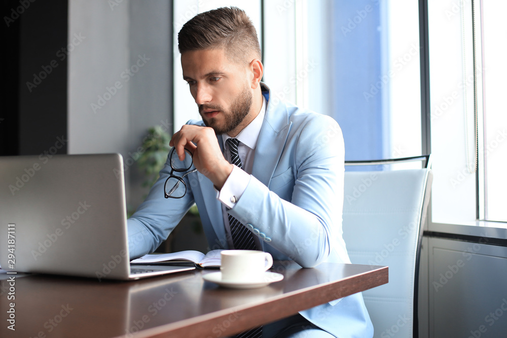 Naklejka premium Modern businessman thinking about something while sitting in the office