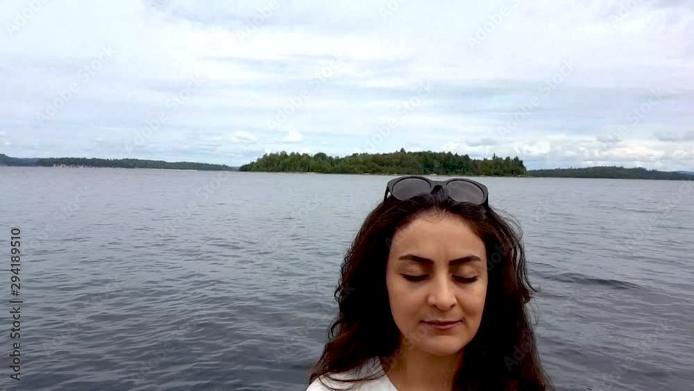 establishing shot showing a woman doing yoga in a wooden pathway to the boat in a sea port with the beauty of nature. establishing shot showing a woman doing yoga in a wooden pathway to the boat in a sea port with the beauty of nature.