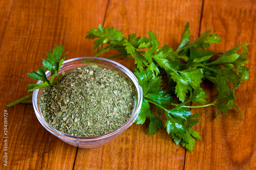 Dried parsley seasoning on wooden table Dried parsley seasoning on wooden table
