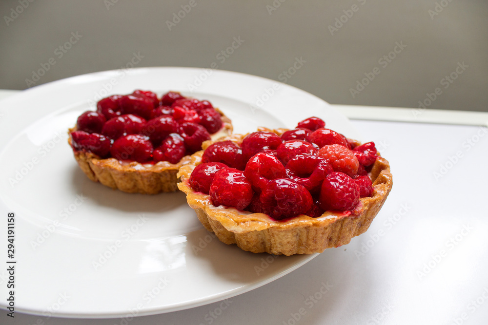 red sugar fresh sweet bakery french tartlet with raspberry on white plate