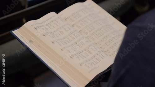 Man Reading Hymnal in Church Pew