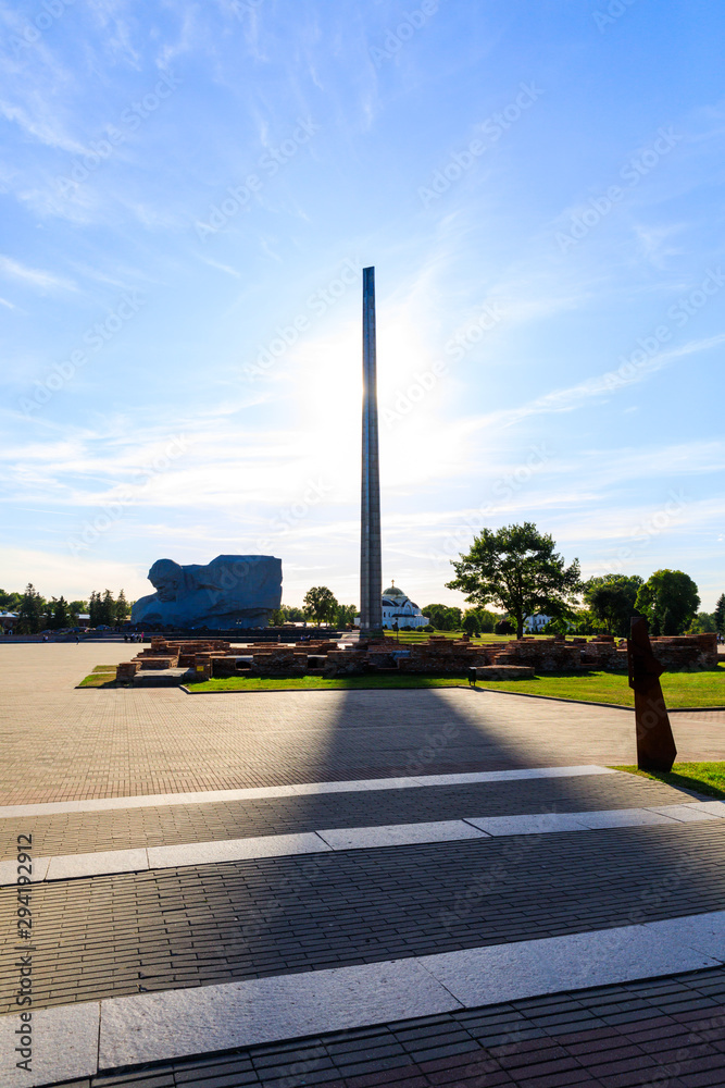 Monument to the soldier defender of the Brest Fortress and a spire in the form of a bayonet of a rifle against the background of the sun. Belarus, first day of World War II in the USSR.