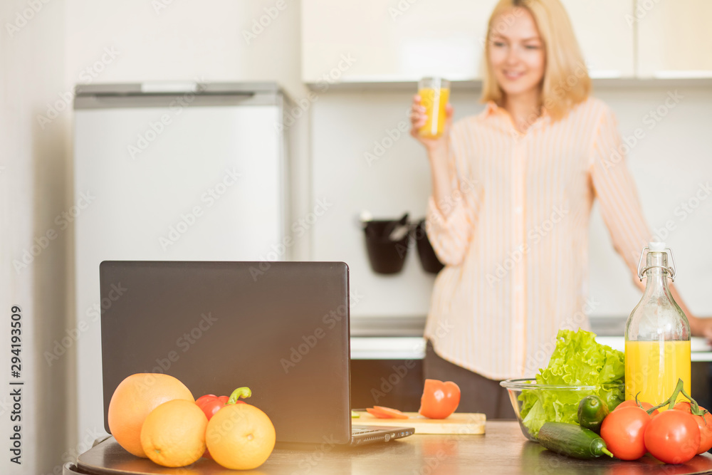 Woman using laptop in the kitchen Woman using laptop in the kitchen