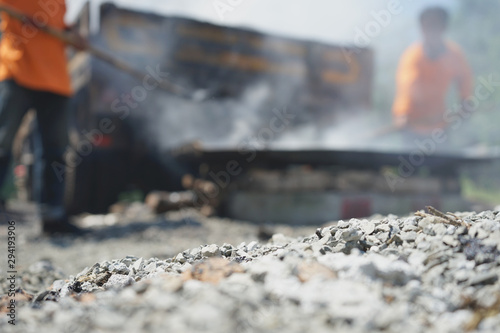 Workers are mixing hot stone caused by burning. Mixed with high temperature asphalt In order to repair the road (blurred images)