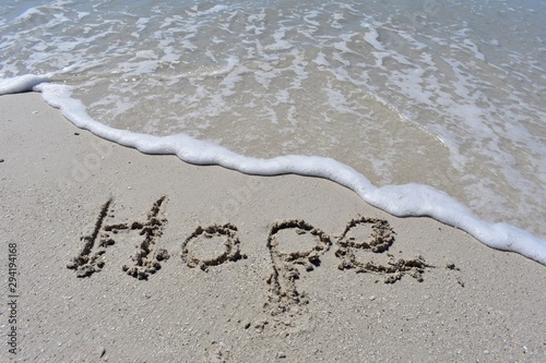Background with hope written in the sand with an ocean wave