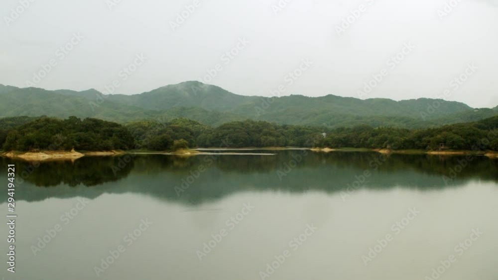 雨 深い霧のかかる山と池に映り込む山のシルエット01 雨 深い霧のかかる山と池に映り込む山のシルエット01