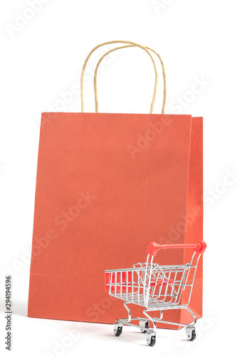 Shopping cart with red shopping bag isolated on white background. photo