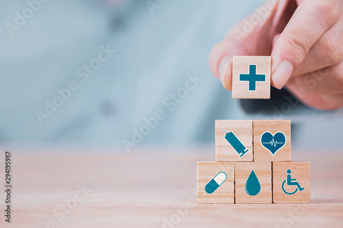 Fototapeta Biznesmen wybiera emoticon ikon opieki zdrowotnej medycznego symbol na drewnianym bloku, opiece zdrowotnej i ubezpieczenia zdrowotnego pojęciu ,.