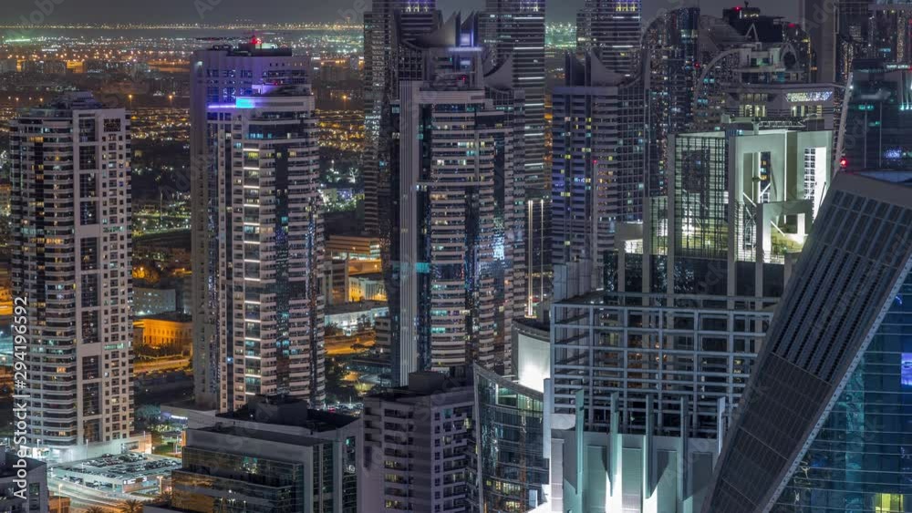 Dubai Marina illuminated skyscrapers and jumeirah lake towers view from the top aerial night timelapse in the United Arab Emirates. Traffic on a road Dubai Marina illuminated skyscrapers and jumeirah lake towers view from the top aerial night timelapse in the United Arab Emirates. Traffic on a road