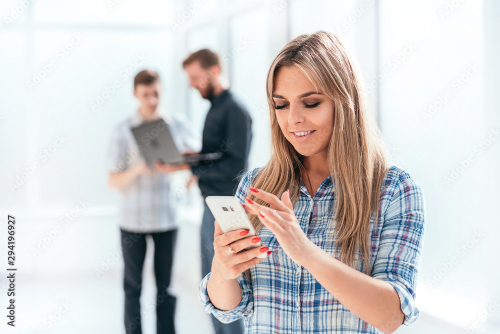 young businesswoman looking at the screen of her smartphone young businesswoman looking at the screen of her smartphone