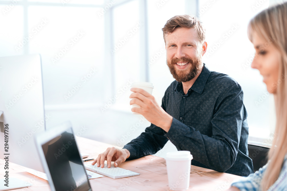 smiling businessman sitting at the office table. smiling businessman sitting at the office table.