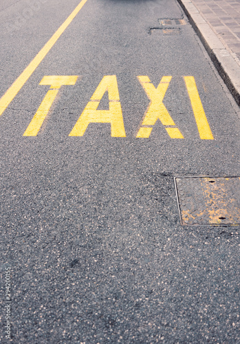 Yellow Taxi sign on blacktop in the city center