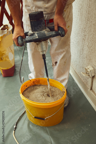 Worker using machine for plastering.