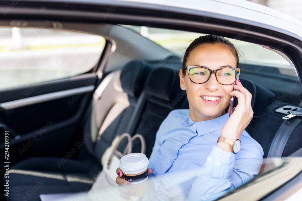 Business woman drinking coffee in the back seat of the car. Beautiful business woman in the car. Business and lifestyle concept. Business woman drinking coffee in the back seat of the car. Beautiful business woman in the car. Business and lifestyle concept.