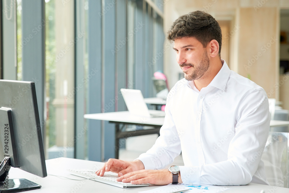 Professional businessman wearing shirt while working on computer in the office