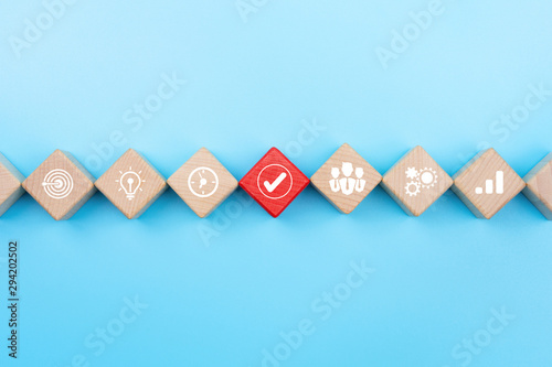 Action plan and Business process management concept, wooden blocks with business strategy icons on blue background, copy space