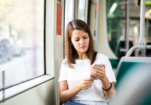 Woman using smartphone in public transport