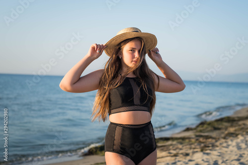 Wallpaper Mural Cheerful plus size teenage girl wearing hat enjoying the beach. smiling, happy, positive emotion, summer style. Torontodigital.ca