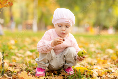 Happy kid in autumn park  plays   with leaves