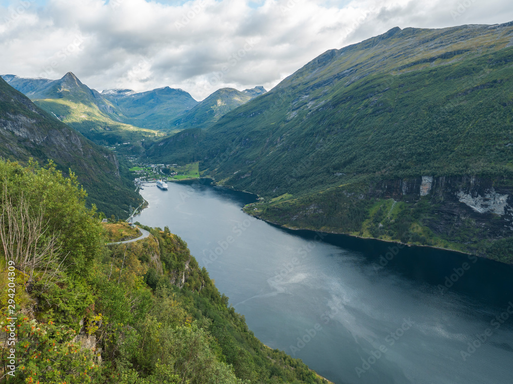 View on Geirangerfjord with big criuse ship in Sunnmore region, Norway, one of the most beautiful fjords in the world, included on the UNESCO World Heritage. View from Ornesvingen eagle road viewpoint