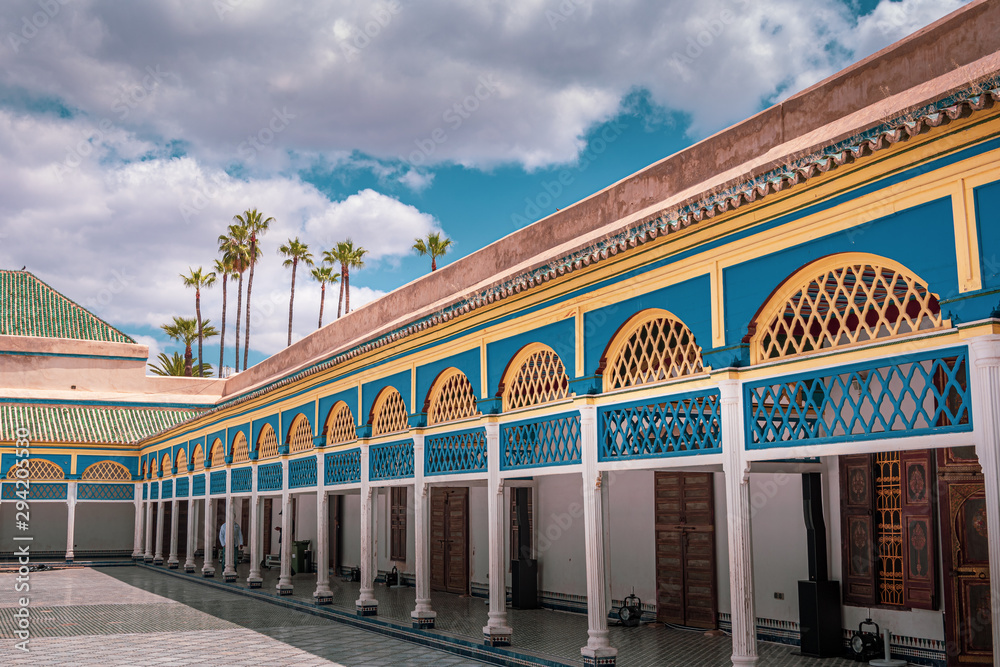 Landscape view of the centre area of the palace, built in traditional form with many decorations. Sky and palm trees in the background Marrakech, Morocco.