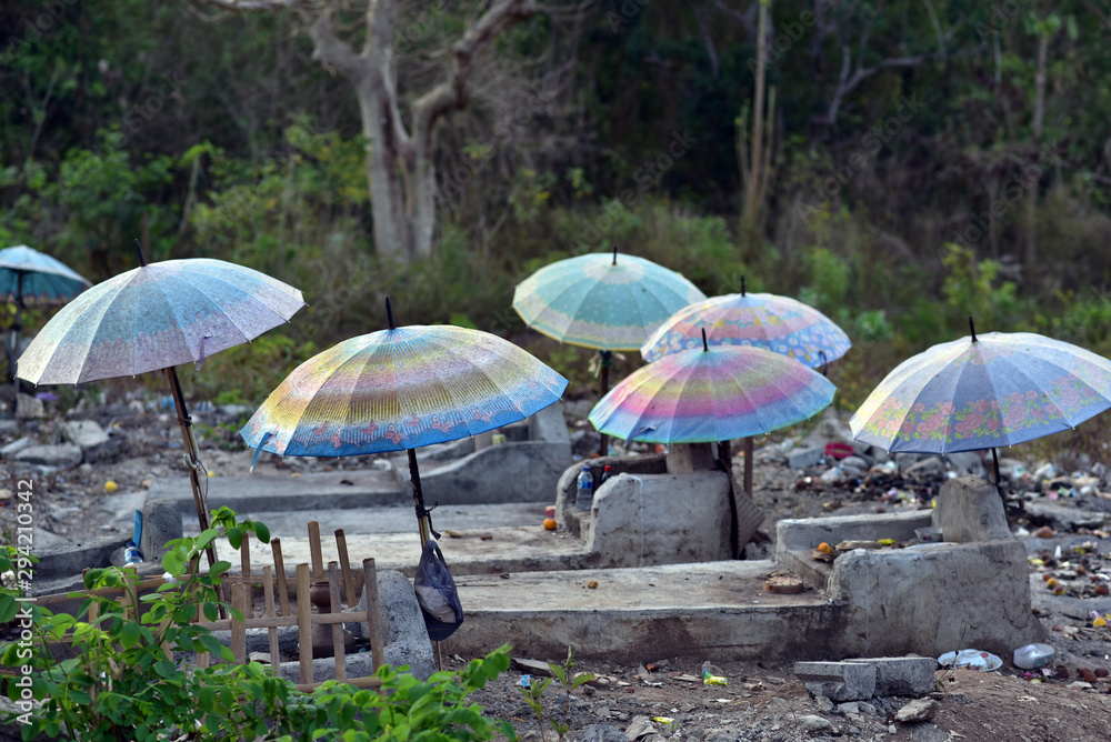 Umbrellas over graves and coffins at Nusa Lembongan cemetery, Indonesia
