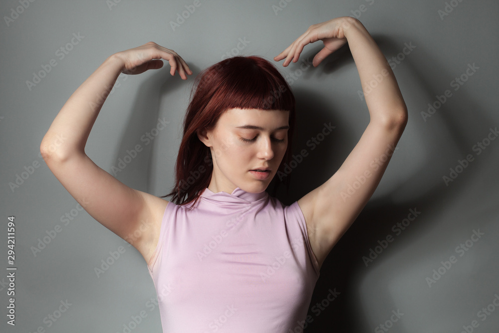 Young woman in pink shirt posing in studio Young woman in pink shirt posing in studio