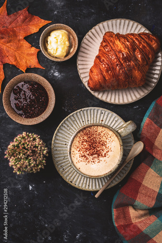cappuccino coffee with croissant on the table, autumn breakfast concept, top view