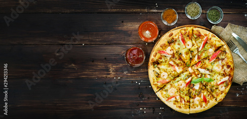 top view, above of seafood pizza, and ingredients, vegetables to decorate around such as tomato chili mushroom garlic. on the wooden table background.