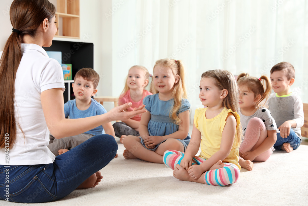 Kindergarten teacher and little children indoors. Learning and playing Kindergarten teacher and little children indoors. Learning and playing