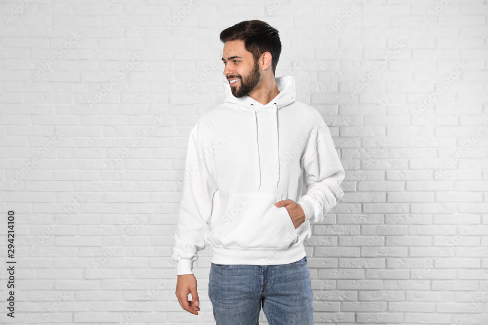 Portrait of young man in sweater at brick wall. Mock up for design Portrait of young man in sweater at brick wall. Mock up for design