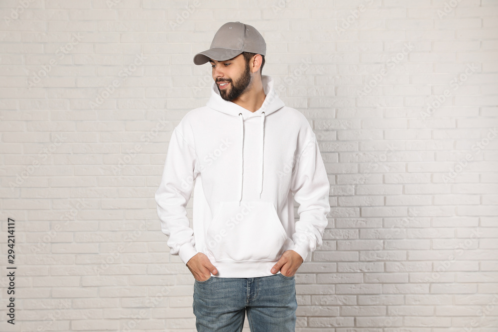 Portrait of young man in sweater at brick wall. Mock up for design Portrait of young man in sweater at brick wall. Mock up for design